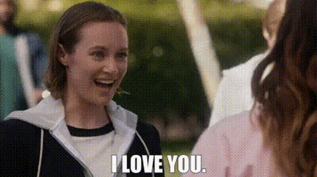 a woman is laughing and saying `` i love you '' while talking to another woman .
