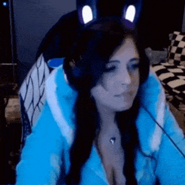 a woman wearing a cat ear headband is sitting in front of a computer .