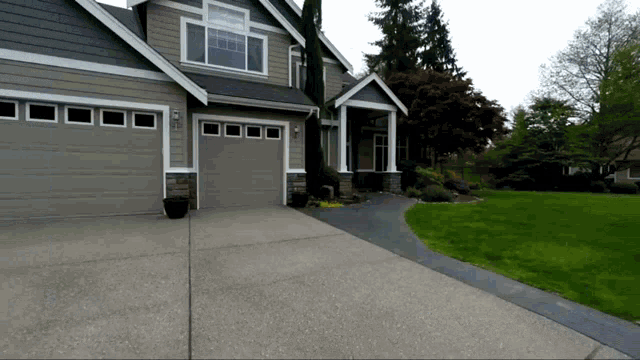 a house with two garage doors and a driveway leading to it