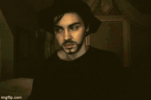a man with a beard is wearing a black hat and a black shirt