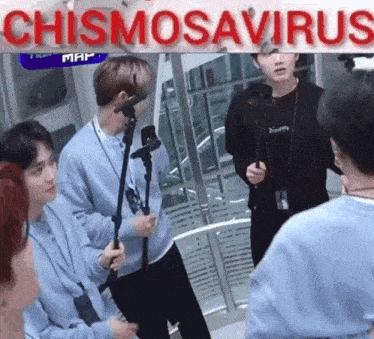 a group of people are standing in front of a sign that says chismosavirus