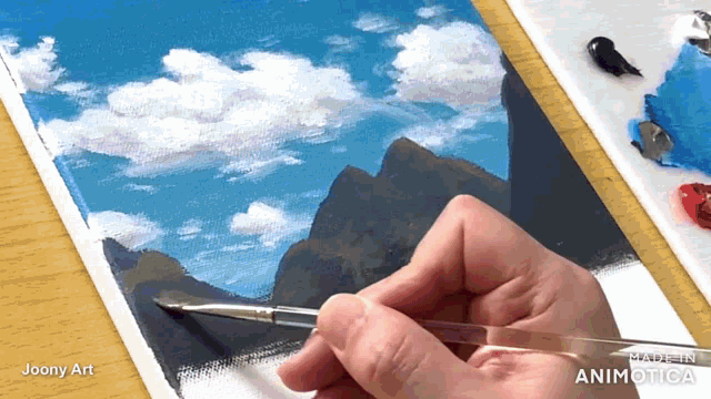 a person is painting a landscape with a brush and the words made in animatica on the bottom right