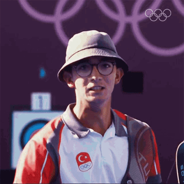 a man wearing a hat and a shirt with a c on it