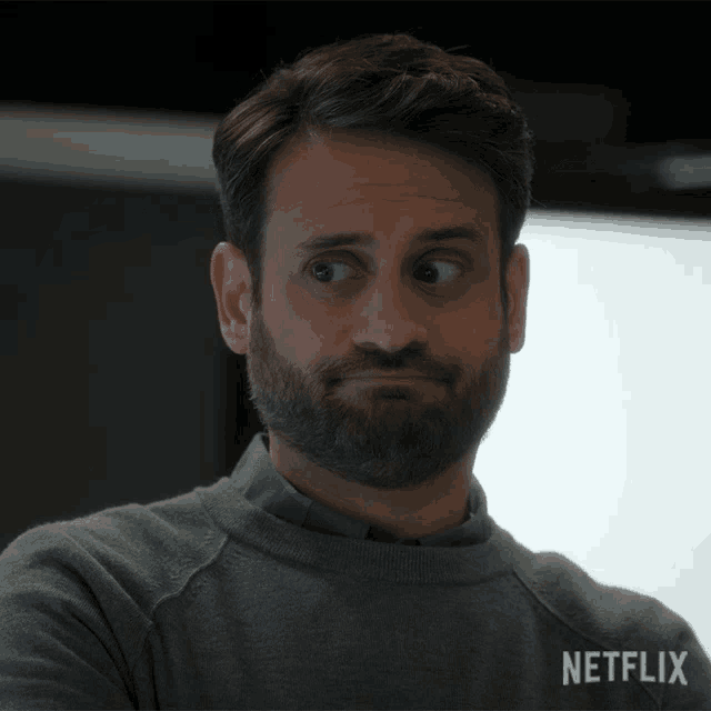 a man with a beard is wearing a sweater that says netflix on it