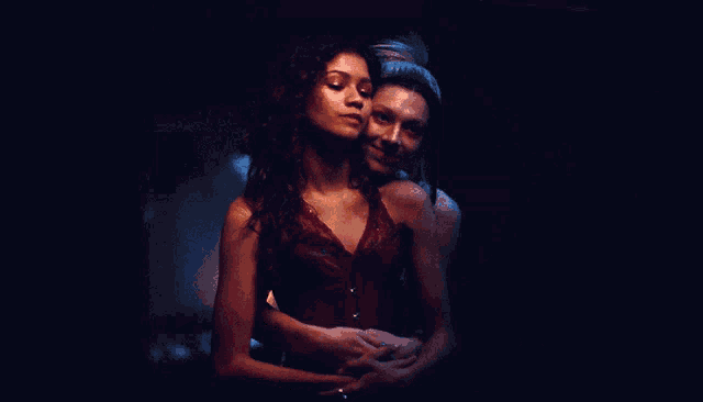 a couple of women hugging each other in the dark