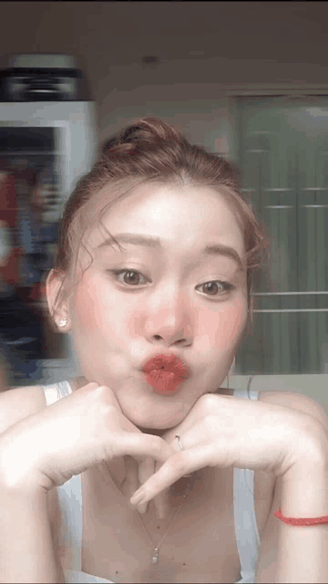 a woman is making a funny face with her hands