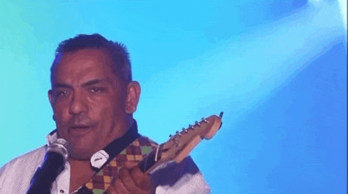 a man is playing an electric guitar on a stage .