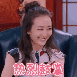 a woman is sitting in a chair and smiling in chinese .