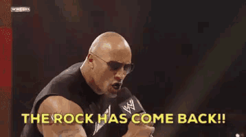 a bald man wearing sunglasses is holding a microphone and saying `` the rock has come back ! ''