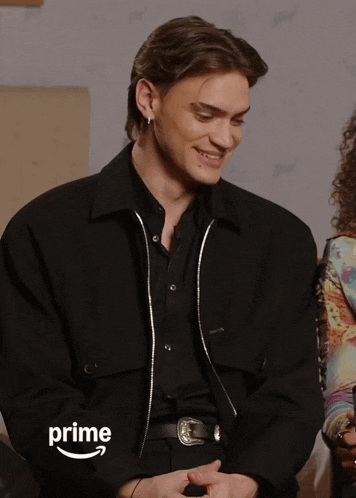 a man wearing a black jacket with the word prime written on the sleeve
