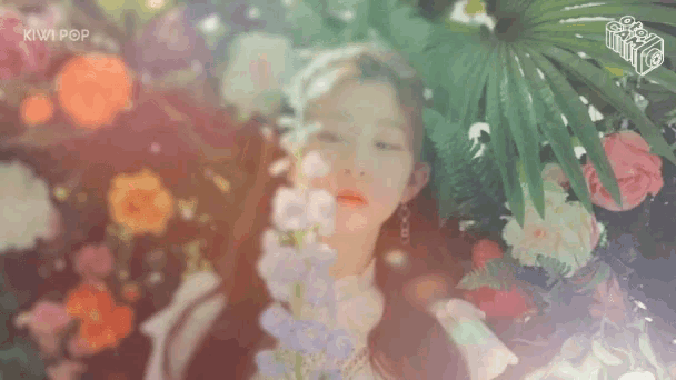 a woman is surrounded by flowers with the words kiwi pop on the bottom