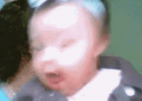 a blurry picture of a baby with a bow on his head