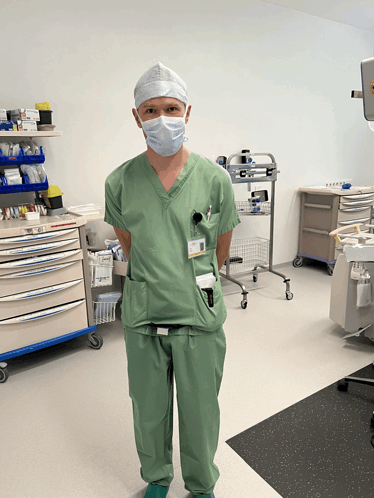 a surgeon wearing a mask and a name tag that says ' surgeon ' on it