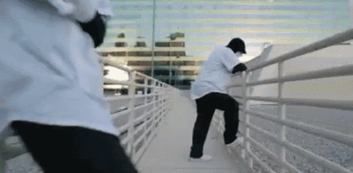 a man in a white shirt is standing next to a railing