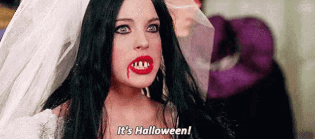 a woman in a vampire costume with blood on her lips is saying `` it 's halloween '' .