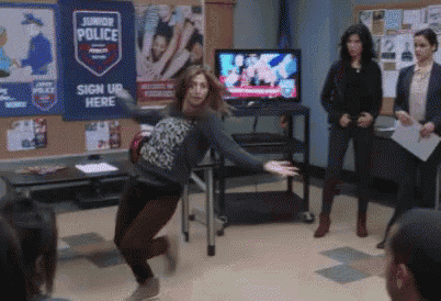a woman is dancing in front of a sign that says junior police sign up here
