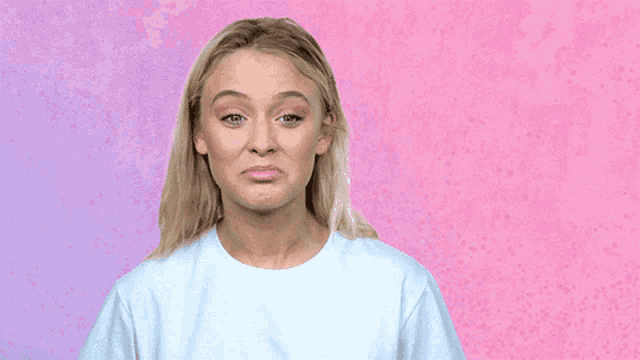 a woman in a white t-shirt is making a sad face