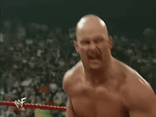 a bald man with a beard and a wrestler 's logo on his shoulder