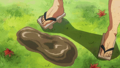 a person wearing flip flops stands next to a puddle of mud