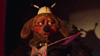 a stuffed animal wearing a viking hat holds a flag