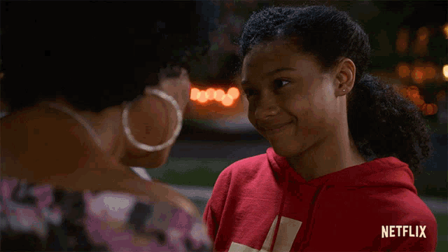 a woman and a girl are looking at each other with a netflix logo in the background