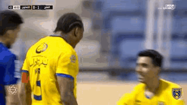 two soccer players are talking to each other on the field .