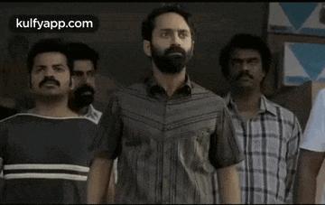a man with a beard is standing in front of a group of men holding hands .