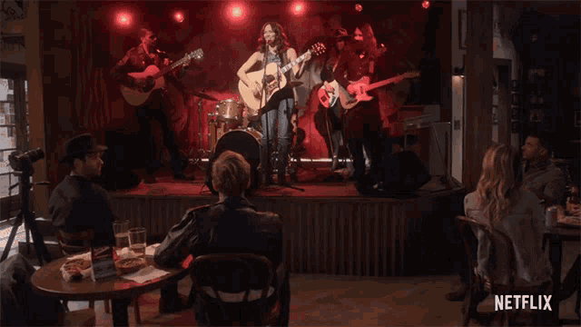 a netflix ad shows a woman singing into a microphone on stage