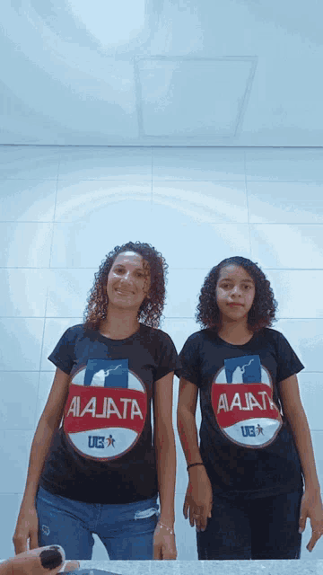 two women wearing black shirts that say aa jata