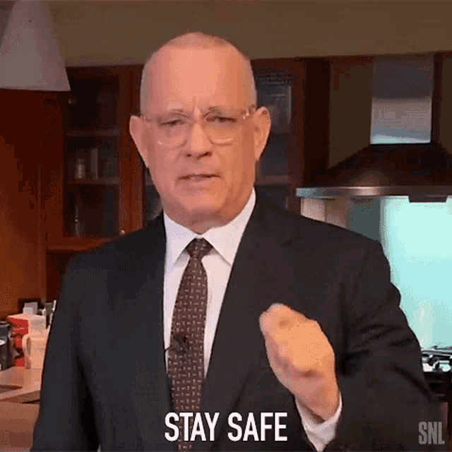 a man in a suit and tie is giving a warning to stay safe
