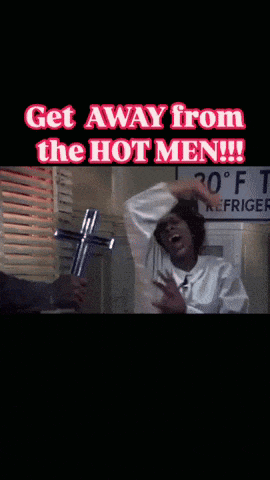 a man holding a cross with the words get away from the hot men