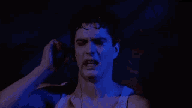 a man is screaming while holding a knife to his ear .