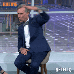 a man in a suit and bow tie is sitting on a stool in front of a netflix sign