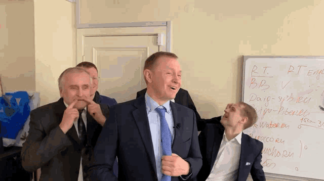 a group of men are standing in front of a whiteboard that says rt temp