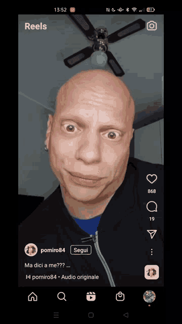 a man with a bald head is making a funny face on a cell phone