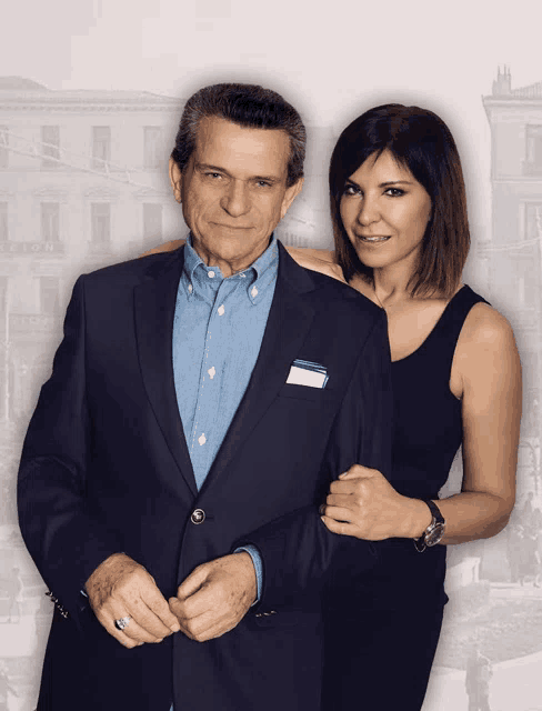 a man in a suit and a woman in a black dress stand next to each other