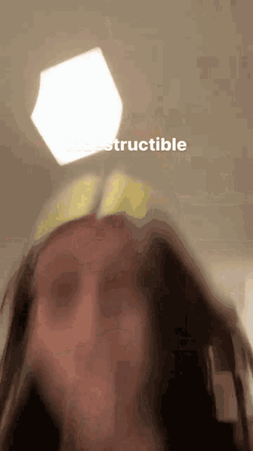 a blurred image of a woman with the word " destructible " written on the bottom