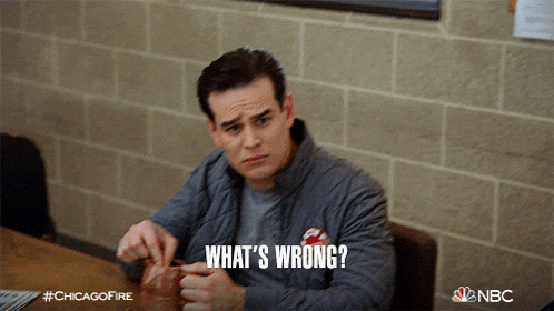a man sitting at a table with the words " what 's wrong " written on his face