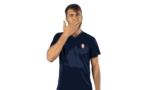 a man with a beard is wearing a blue adidas shirt and making a gesture with his hand .