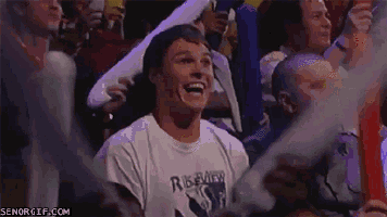 a man in a white shirt is screaming in front of a crowd of people .