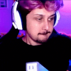 a man with purple hair is wearing headphones and holding a microphone .