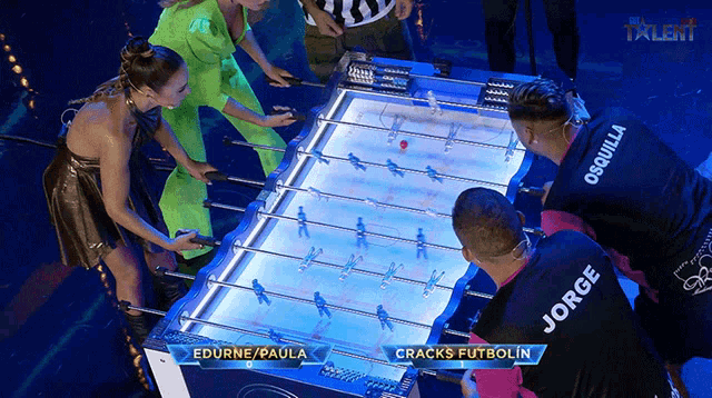 a group of people are playing a game of cracks futbolin
