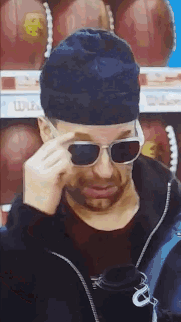a man wearing sunglasses and a hat looks at something