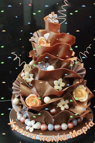 a chocolate cake with flowers and beads and the words xoovia to aaa mapia on the top
