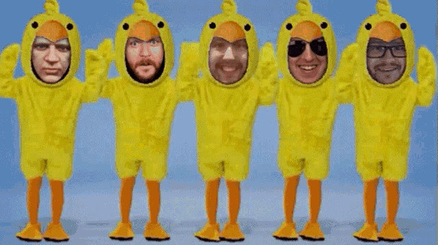 a group of people dressed in yellow ducks with faces on them