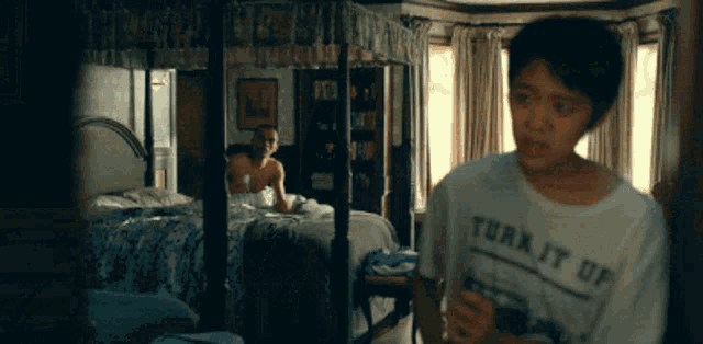 a young boy wearing a shirt that says turn it up