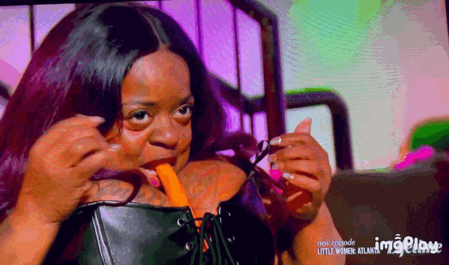 a woman is eating a carrot with the words little women atlanta on the bottom