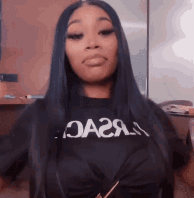 a woman with long black hair is wearing a black t-shirt that says oa2a .