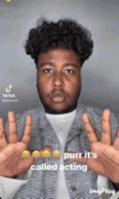 a man with curly hair is making a funny face with his hands up .