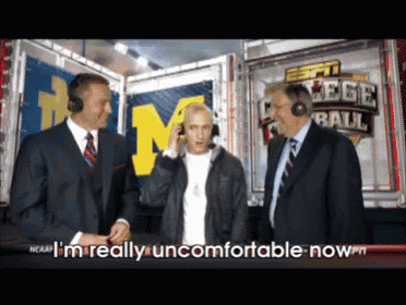 a man wearing headphones talks to two men in front of a sign that says ncaa